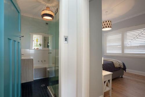 una camera da letto e un bagno con un letto di Barefoot in Bronte IH a Sydney