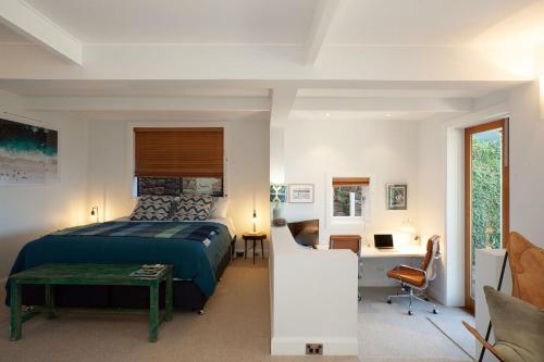 a bedroom with a king sized bed and a desk at Barefoot in Bronte IH in Sydney