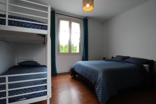 une chambre avec deux lits superposés et une fenêtre dans l'établissement 8 couchages à 6 klm des plages, à Saint-Denis-du-Payré