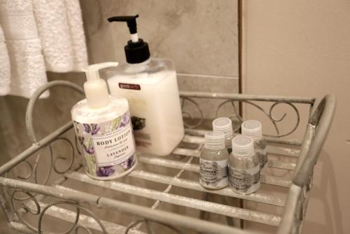 a metal rack with bottles of soap and a mirror at A La Maison Boutique Guesthouse in Parys