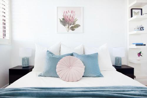 a bed with a pink and blue pillow on it at Centennial Retreat in Sydney