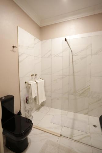 a bathroom with a toilet and a glass shower at A La Maison Boutique Guesthouse in Parys