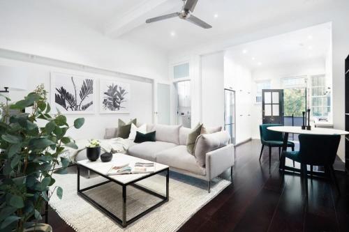 a living room with a white couch and a table at Woollahra Contemporary in Sydney