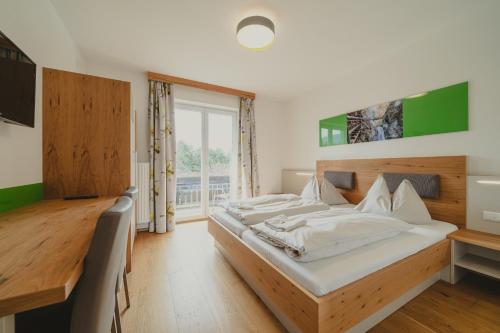 a bedroom with two beds and a large window at Hotel Semriacherhof in Semriach