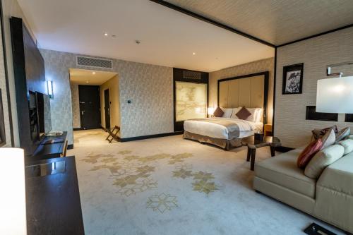 Habitación de hotel con cama y sofá en غرفة بريميوم ببرج العنود en Riad