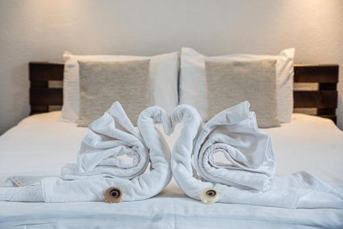 two towels shaped like swans sitting on a bed at Hunnia - Huntanya in Vlăhiţa
