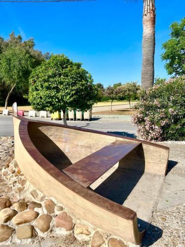 a wooden bench sitting on top of a pile of rocks at El Txoko Andaluz in Cantillana