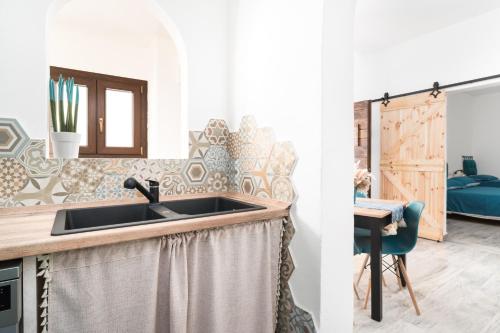 een keuken met een wastafel en een slaapkamer bij S' Istancu Vetzu in Irgoli