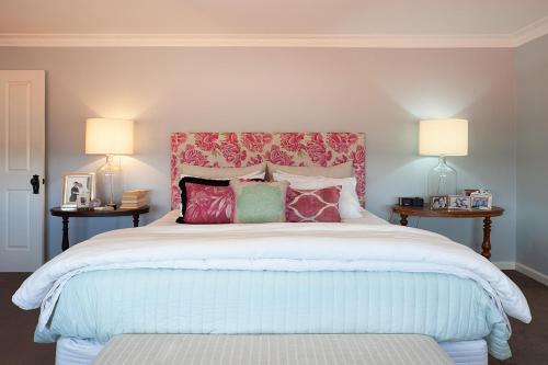 1 dormitorio con 1 cama grande y cabecero rojo en Colourful Coogee en Sídney