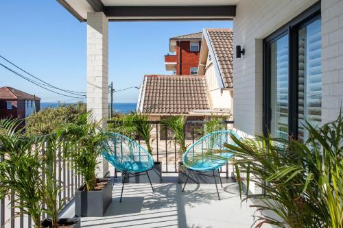 a patio with two chairs and a view of the ocean at Coastal Tamarama in Sydney