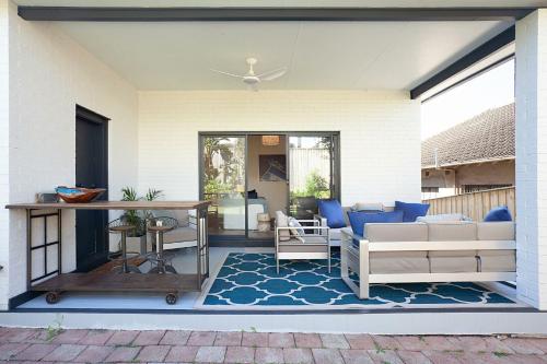 a patio with a couch and a table on a rug at Coastal Tamarama in Sydney