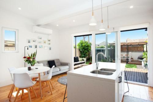 a kitchen and living room with a table and chairs at Garden Oasis Sydenham in Sydney
