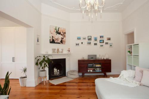 a living room with a chandelier and a fireplace at Garden Oasis Sydenham in Sydney