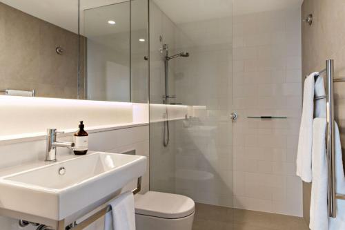 a bathroom with a sink and a toilet and a shower at Cosmopolitan Heights in Sydney