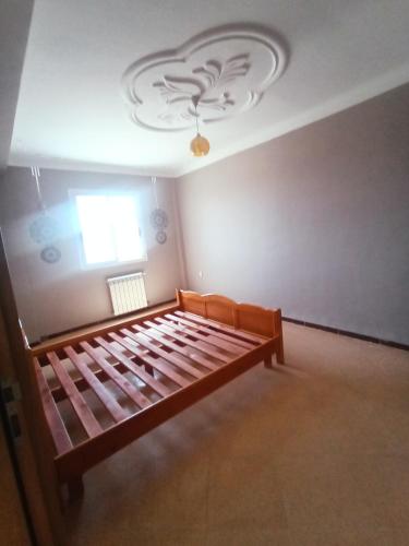 ein Schlafzimmer mit einem Bett in einem Zimmer mit einem Fenster in der Unterkunft EL SARAYA M'SILA DZ in MʼSila