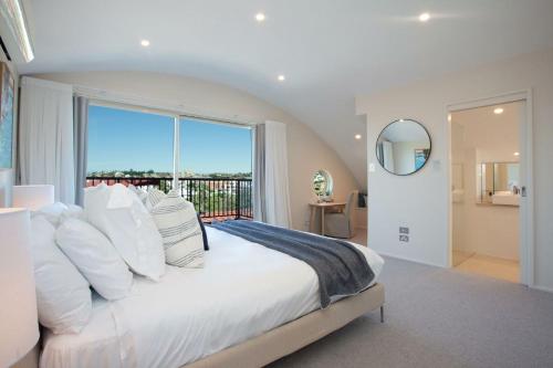 een slaapkamer met een groot wit bed en een groot raam bij Gordons Bay Vista in Sydney