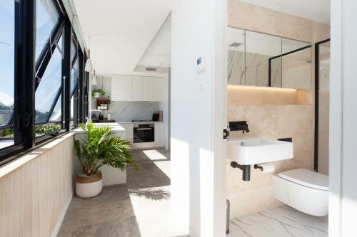 uma casa de banho com um lavatório e um espelho em The Treehouse Penthouse em Sydney
