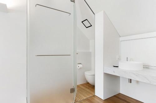 een witte badkamer met een toilet en een wastafel bij The Loft in Sydney