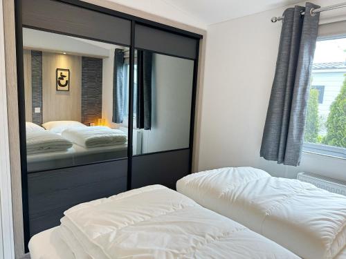 a bedroom with two beds and a large mirror at Chalet 531a op Recreatiepark De Wielen in Sint Maarten