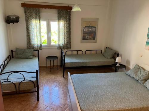 sala de estar con 2 camas y ventana en The Family Place - Cosy Double bedroom apartment on beach of Kallithea, Chalkidiki, en Kallithea Halkidikis