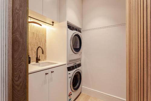 a laundry room with a washer and dryer next to a sink at The Timeless Modern Glebe in Sydney