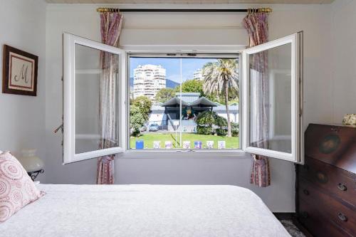 1 dormitorio con ventana y vistas a un edificio en Torremolinos Playamar Primera Linea de Playa Urb. La Farola, en Torremolinos