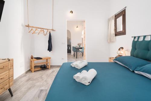 1 dormitorio con 1 cama azul y toallas en el suelo en S' Istancu Vetzu, en Irgoli