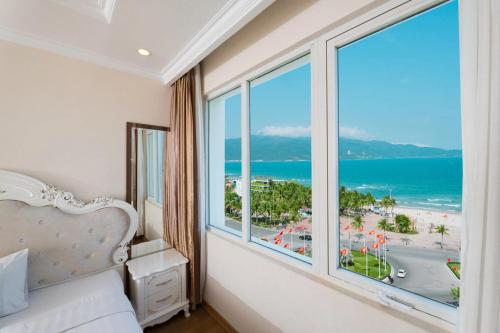 a bedroom with a large window with a view of the ocean at Tuyet Son Hotel (TS Ocean Hotel) in Danang