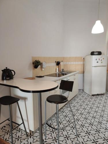 cocina con mesa, 2 sillas y nevera en Apartment Mariacki Tower, en Cracovia