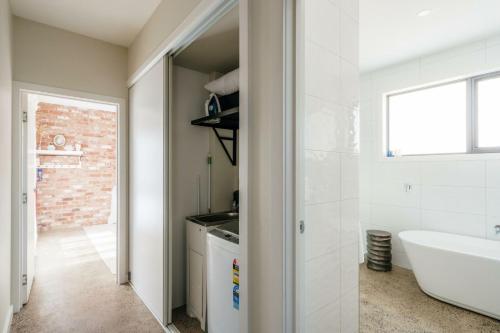 ein Badezimmer mit einer weißen Badewanne, einem Waschbecken und einer Badewanne in der Unterkunft Embracing Evandale in Evandale