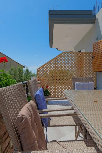 a patio with wicker chairs and a table at Vila Nanaj in Sarandë