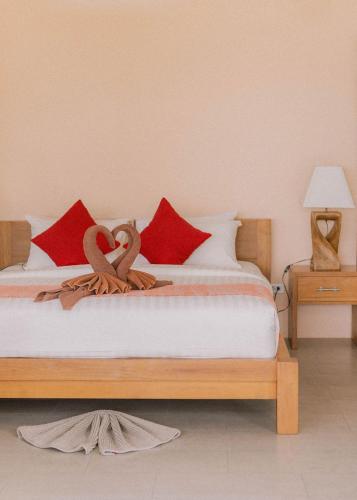 a bedroom with a bed with red pillows and two swans on it at Perfect View Pool Villa in Koh Tao