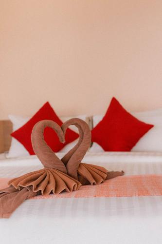 two heart shaped towels on a bed with red pillows at Perfect View Pool Villa in Koh Tao