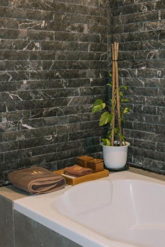 a bath tub with a potted plant next to a brick wall at Perfect View Pool Villa in Koh Tao