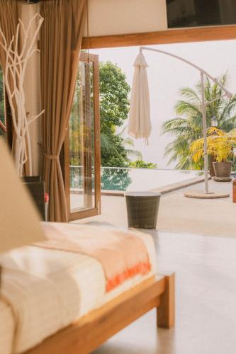 a bedroom with a bed and a view of a patio at Perfect View Pool Villa in Koh Tao