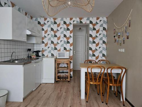 une cuisine avec une table et des chaises dans une cuisine dans l'établissement Appartement Cœur de Ville !, à Saint-Omer