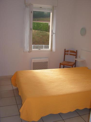 une chambre avec un lit jaune et une fenêtre dans l'établissement Residence Albizia, à Gréoux-les-Bains