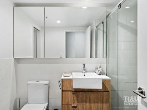 W łazience znajduje się umywalka, toaleta i lustro. w obiekcie One Oak w mieście Brisbane