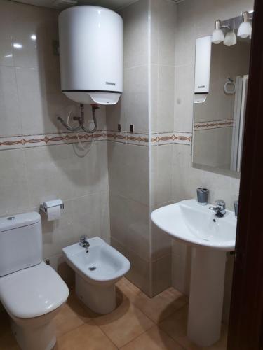a white bathroom with a toilet and a sink at Apartamento Mandala in Deltebre