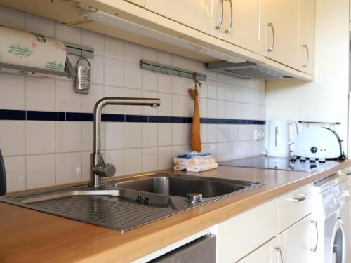 uma cozinha com um lavatório e uma bancada em Fernsicht-12b-EG em Wenningstedt