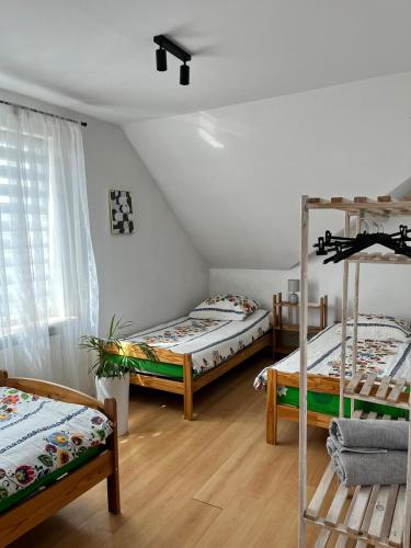 a room with three bunk beds and a window at APARTMENT ON THE ROAD S-61 in Szypliszki