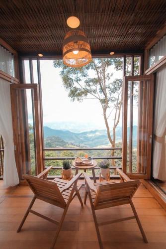 a room with a table and chairs and a large window at U villa in Ban Huai Khai