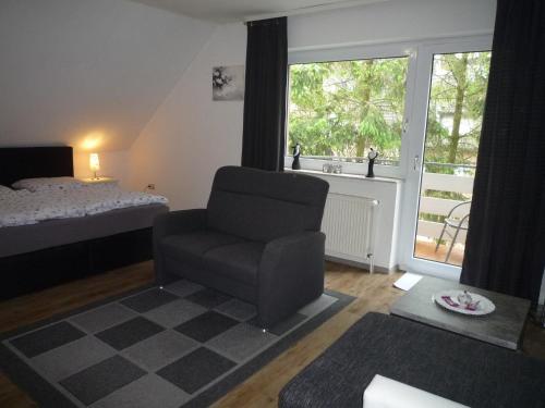 a bedroom with a chair and a bed and a window at Ferienwohnung Alte Kämpe in Heede