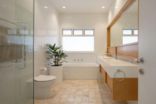 e bagno con servizi igienici, lavandino e doccia. di The Cali Beach house Bronte a Sydney