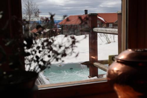 una ventana con vistas a un patio cubierto de nieve en Fryksas Chalet, en Fryksås