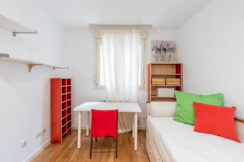 マドリードにあるPlenilunio Arcauteのベッドとテーブル付きの小さな部屋