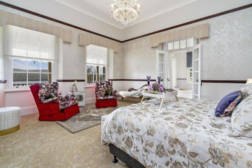 - une chambre avec un grand lit et deux chaises dans l'établissement Pointe Rapide Estate, à Rowella