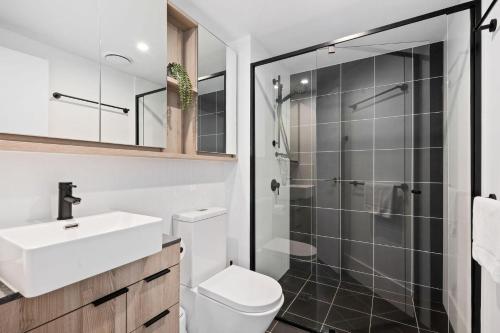 a bathroom with a toilet and a sink and a shower at Queen Windsor in Brisbane