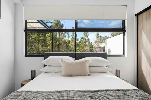 sypialnia z białym łóżkiem i dużym oknem w obiekcie Queen Windsor w mieście Brisbane