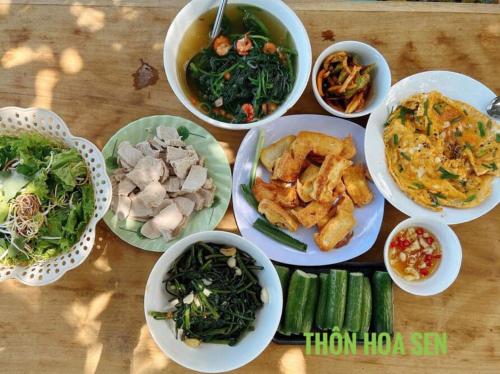 a table with different dishes of food on it at Thôn Hoa Sen in Thôn Xuân Lỗ
